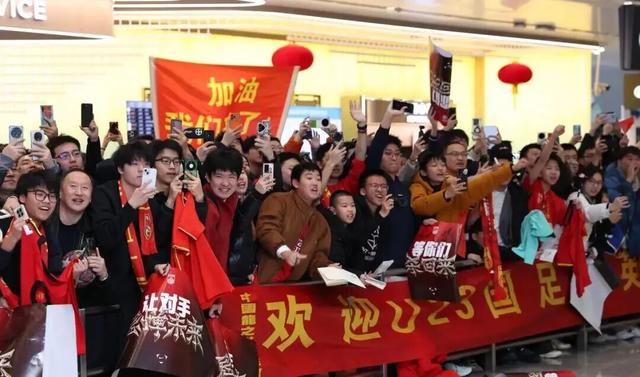 球迷热情接机U23国足，现场一球迷大爷动情寄语：“坚信四年到八年后，中国足球一定能坐稳亚洲前列！