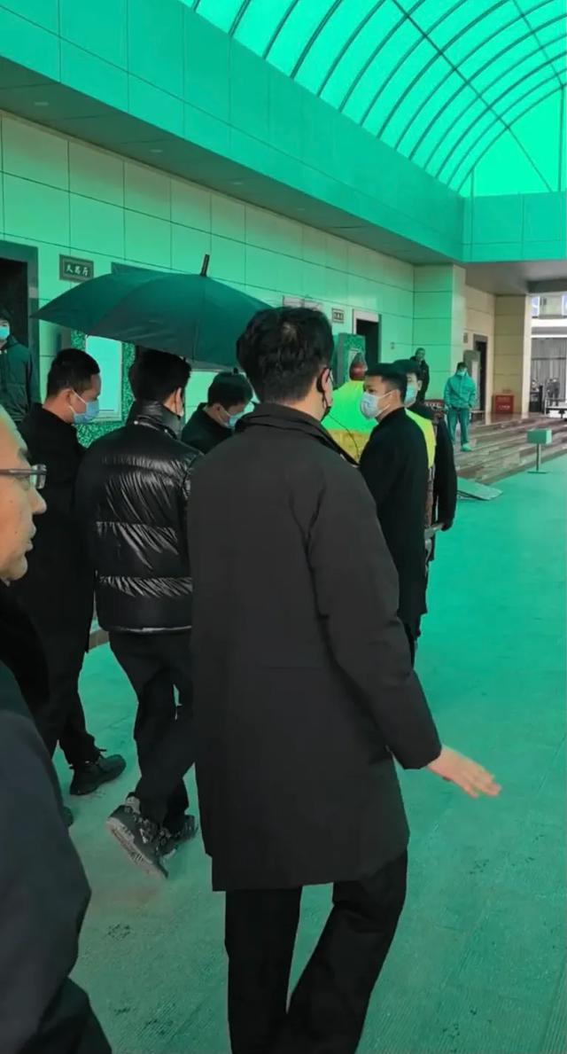 许何弯着腰抱着何晴遗像，背影很难过	，许亚军没来给何晴撑伞！