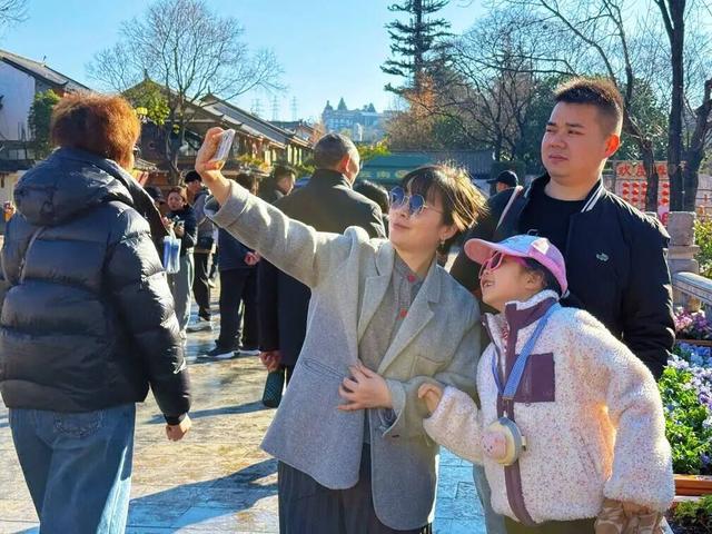 【网络中国节·春节】花海人潮映古城，八方游客来丽江过年