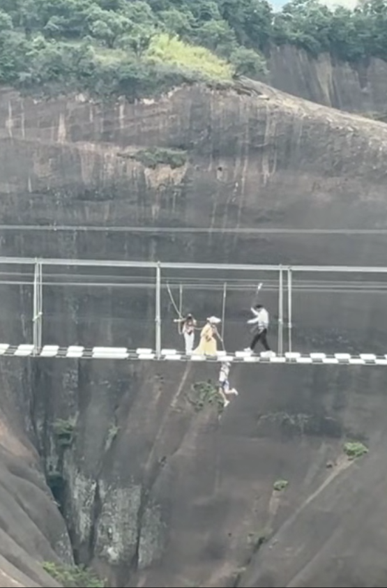 男孩疑踩空半截身子悬空200多米高玻璃栈道，呼救后安全员及时拉上来；景区：系有安全绳