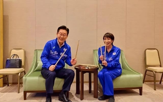 高市早苗和李在明穿同款衣服一起打架子鼓，现场赠送李在明鼓棒并教其打法	，韩媒：该活动没提前打招呼