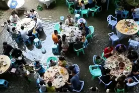 湖南男子雨中办酒席，亲友坐在水里喝酒，网友：这才叫“流水席”图片