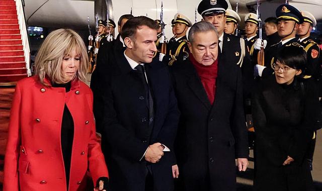 72岁法国第一夫人抵京惊艳	，红大衣配戴妃包超美