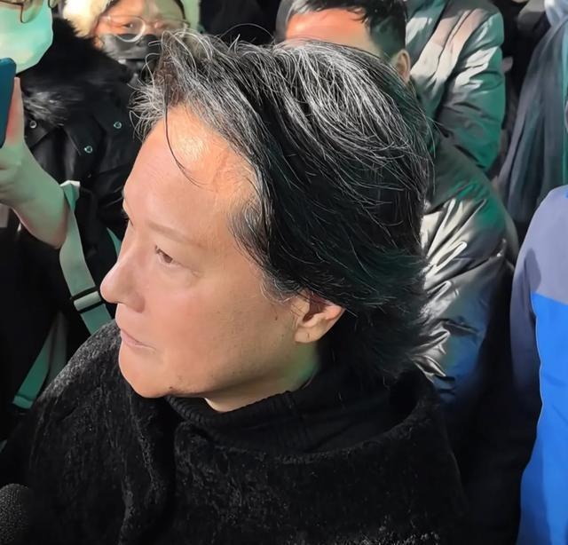 许何弯着腰抱着何晴遗像，背影很难过，许亚军没来给何晴撑伞！