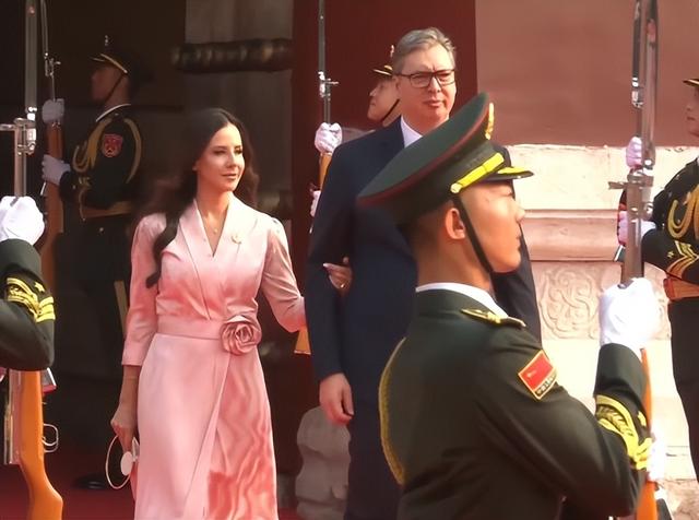 武契奇夫人观看阅兵美翻了！粉色玫瑰花裙好温婉，挽着武契奇很甜