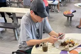 林俊杰在新加坡吃大排档，打扮朴素，手机打游戏，不在意路人目光图片