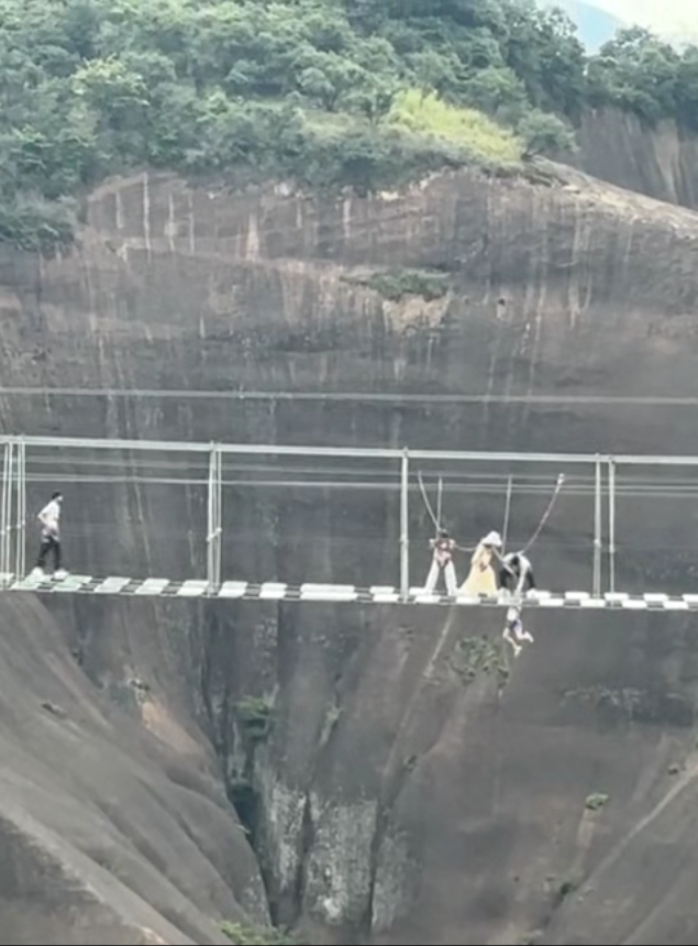 男孩疑踩空半截身子悬空200多米高玻璃栈道，呼救后安全员及时拉上来；景区：系有安全绳