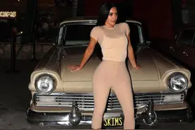 44岁金·卡戴珊穿薄款肤色塑身衣躺车上，撩黑发，三个孩子在旁边图片