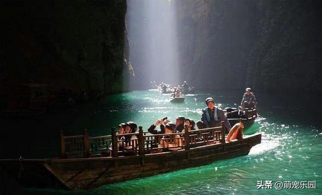 峡谷小溪清澈见底，阳光金束洒水面，小木船如仙境般飘过