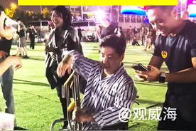 男子坐轮椅去看音乐节，路过的歌迷们纷纷前来合影！图片