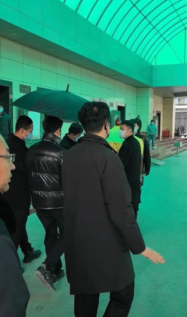 许何弯着腰抱着何晴遗像，背影很难过	，许亚军没来给何晴撑伞！