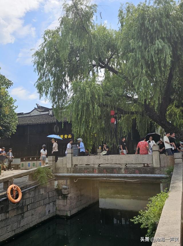 平江路打伞避暑的姑娘，平静的河水，悠悠的乌篷船，悠久的历史