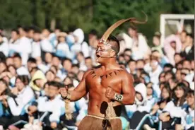 云南一中学体育节师生赤膊表演彝族战舞：光头前副校长吹号角，物理老师表演喷火图片