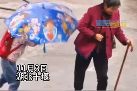 风雨中女孩努力垫脚为伞坏的老人撑伞图片