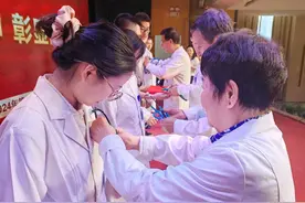 老专家为新人赠送听诊器，纪念第七个“中国医师节”图片