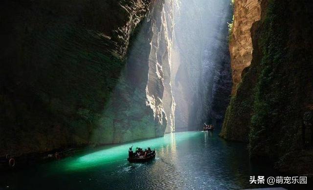 峡谷小溪清澈见底，阳光金束洒水面，小木船如仙境般飘过