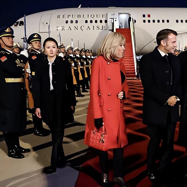 72岁布里吉特真洋气	，红大衣配高跟鞋美翻了，挽着马克龙胳膊好甜