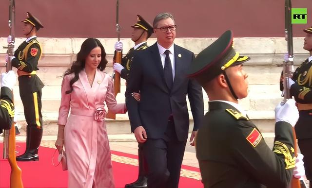 武契奇夫人观看阅兵美翻了！粉色玫瑰花裙好温婉，挽着武契奇很甜