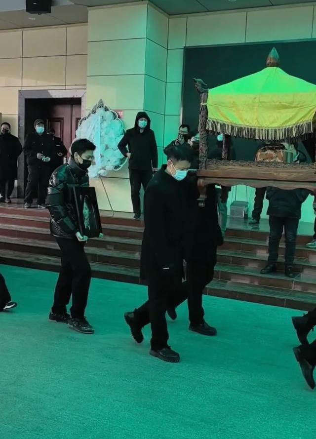 许何弯着腰抱着何晴遗像，背影很难过，许亚军没来给何晴撑伞！