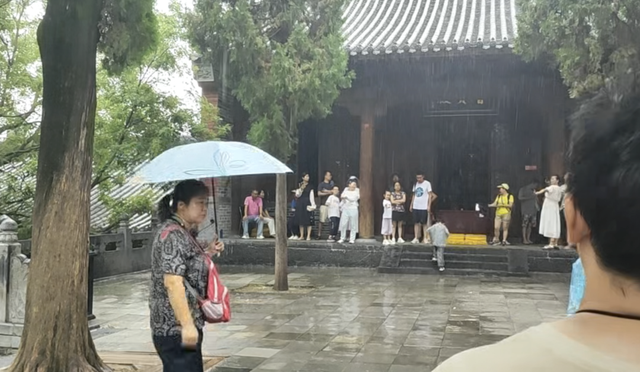 多名游客还原“风雨少林”：能躲雨的地方很多，僧人主动邀请进殿躲雨
