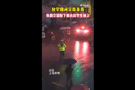 放学期间突降暴雨，执勤交警脱下雨衣给学生披上图片