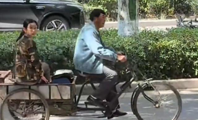 55岁张嘉益在西安骑三轮车，车上坐着秦海璐，民工的打扮很接地气