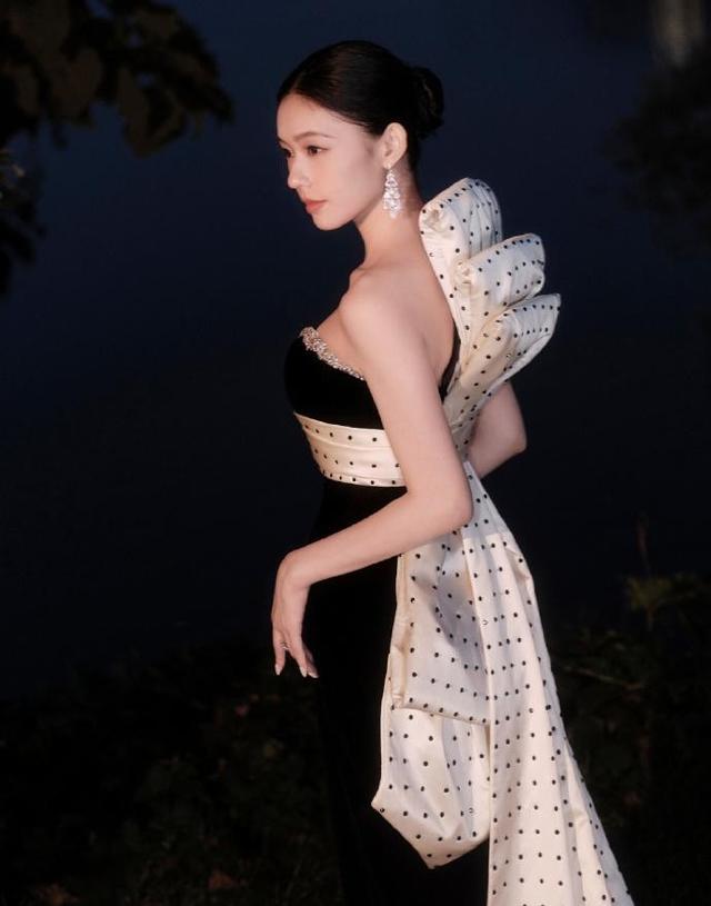 夜色中一袭黑裙惊艳全场，V领宝石闪耀夺目，躺草地展现完美曲线