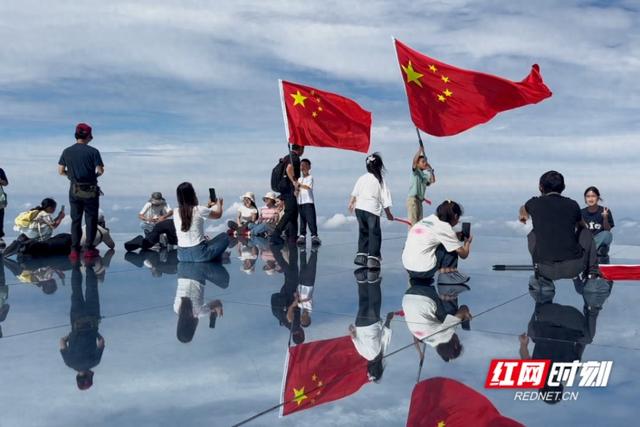 大美红图丨最爱中国红 游客在天空之镜舞动国旗