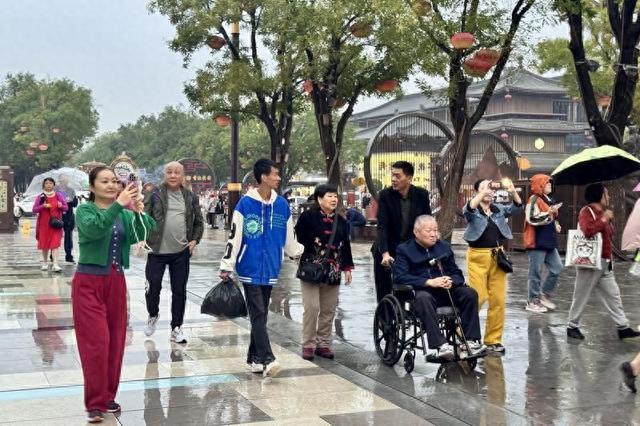 漫步不夜城 雨天游客热情不减
