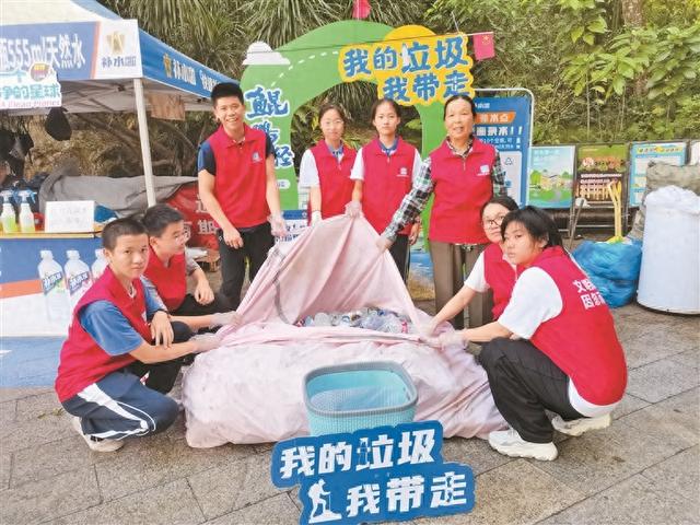 垃圾带下山 空瓶兑饮料  国庆中秋长假期间，深圳“山海捡塑”活动回收塑料瓶近10万个