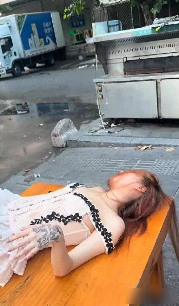 女子晚上喝得酩酊大醉，躺在烧烤摊的桌子上睡着了：天亮了还没醒