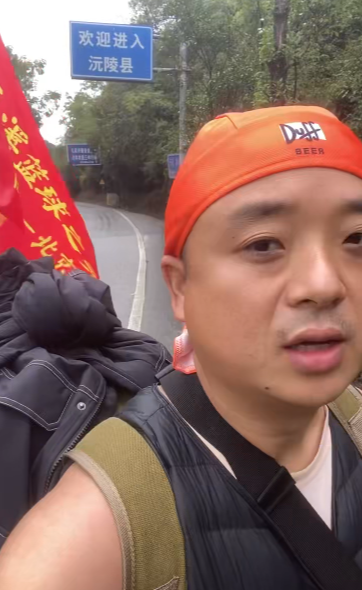 小伙称从怀化徒步1600多公里去北京，携带旗子写满当地特产名，本人回应作秀质疑