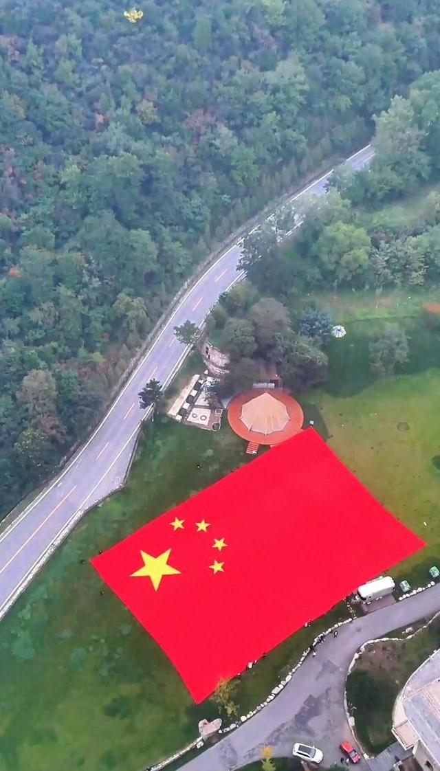 山西云丘山现1650平方米巨型五星红旗，100名游客共同托起，景区：国庆假期每天邀请游客“共举国旗”