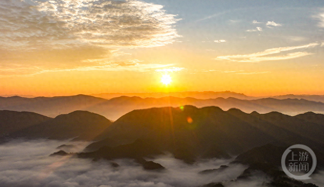 晨雾缭绕间，日出点亮山村