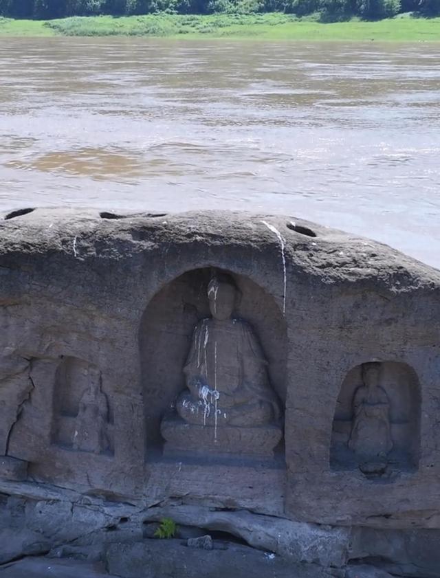 长江重庆段水位下降露出600年历史石佛，许多游客隔岸参观祈福
