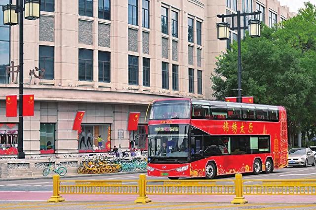 太原街头，游客乘坐全新双层观光巴士开启游览之旅