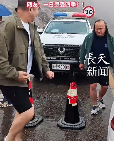 新疆伊昭公路8月突然降雪，游客穿着短裤在雪中跺脚