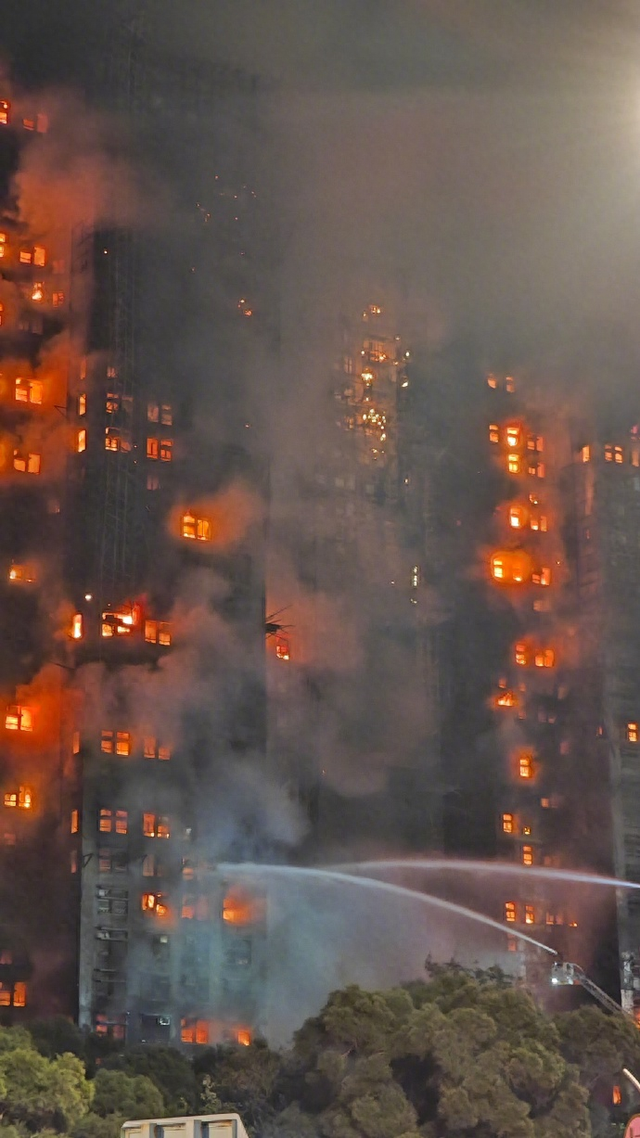 航拍香港火灾现场，多幢大厦被火光笼罩；受灾楼栋住户近万人，老年人居多，居民发声：被安置在附近中学
