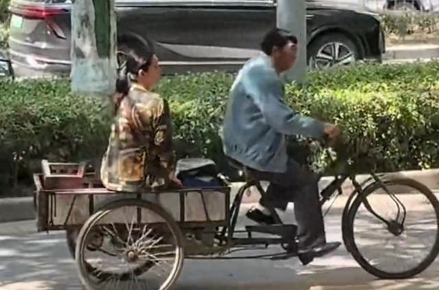 55岁张嘉益在西安骑三轮车，车上坐着秦海璐，民工的打扮很接地气