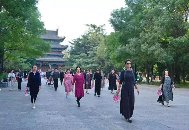 太原市民在迎泽公园里随着音乐节奏走着模特步