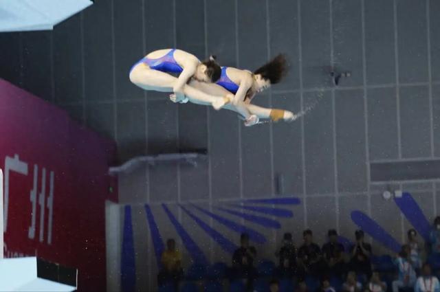 全红婵时隔五月重返赛场，出战女子团体双人10米台，第一跳结束后排名第一	，看台上都是为她加油的海报