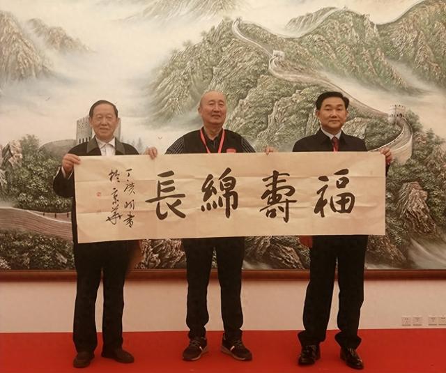 丁广明向第三届“长寿之星”老干部老同志迎新年茶话会赠送书法