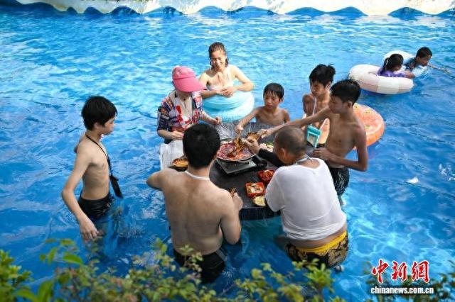 水中冲浪、吃火锅 重庆民众趣味消暑享受清凉