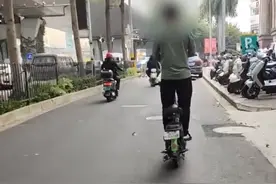 海口一男子站立在电动车上骑行，双手离开车把看得人心惊胆战，大哥，是座位太烫了吗？#惊险一幕#神操作 #海南dou知道 @海南交警 视频封面