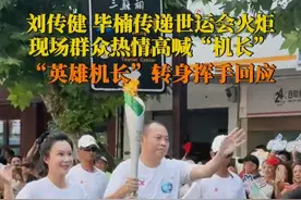 7月26日，#2025成都世运会 “中国民航英雄机组”成员刘传健、毕楠传递世运会火炬，现场群众高呼“机长”，刘传健转身热情挥手回应。