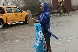 雨天限定快乐！父子俩站路边被路过车辆溅水，举起的牌子上写着“滋我”。（来源：Sun.）#父子日常视频封面