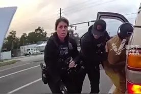美国佛罗里达州一男子闯红灯被拦，女警上前搜身拔出其随身配枪时走火，击中男子大腿，尴尬看向同事。视频封面