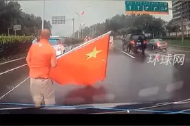 路边国旗被吹落，司机停车冒雨捡起，后方车辆无人鸣笛催促视频封面