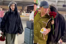 42岁范冰冰现身机场，颜值气质仍在线，拿玫瑰花和男友人窃窃私语