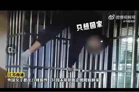 江苏南通：外籍女子翻窗回家被困21楼防盗窗图片